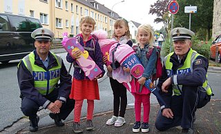 Passen auf: Polizeioberkommissar Rainer Hoberg (l.) und Polizeioberkommissar Reinhard Schnitz mit drei Schulanfängern mit ihren Schultüten. - Polizei Paderborn Passen auf: Polizeioberkommissar Rainer Hoberg (l.) und Polizeioberkommissar Reinhard Schnitz mit drei Schulanfängern mit ihren Schultüten. - Polizei Paderborn