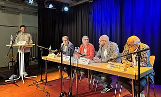 Moderator Denis Utas und die Bürgermeisterkandidatin und -kandidaten auf dem Podium in der Druckerei. - Nicole Sielermann Moderator Denis Utas und die Bürgermeisterkandidatin und -kandidaten auf dem Podium in der Druckerei. - Nicole Sielermann