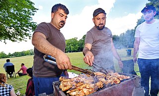 Khaled Kassem (Mitte) hat jede Menge Hähnchenfleisch auf den Grill gelegt. Beim Treffen mit der Großfamilie auf dem öffentlichen Platz an den Heeper Fichten an diesem Sonntag gedenkt er auch seiner kürzlich im Irak verstorbenen Mutter. - Barbara Franke Khaled Kassem (Mitte) hat jede Menge Hähnchenfleisch auf den Grill gelegt. Beim Treffen mit der Großfamilie auf dem öffentlichen Platz an den Heeper Fichten an diesem Sonntag gedenkt er auch seiner kürzlich im Irak verstorbenen Mutter. - Barbara Franke