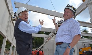 Wolfgang Soldan, ehemaliger Leiter des Betonfertigteilwerks Bielefeld (l.), und Bauleiter Achim Bokermann beobachten, wie eine Strebe für das Dach der Sporthalle heranschwebt. Foto: Sibylle Kemna - Sibylle Kemna Wolfgang Soldan, ehemaliger Leiter des Betonfertigteilwerks Bielefeld (l.), und Bauleiter Achim Bokermann beobachten, wie eine Strebe für das Dach der Sporthalle heranschwebt. Foto: Sibylle Kemna - Sibylle Kemna