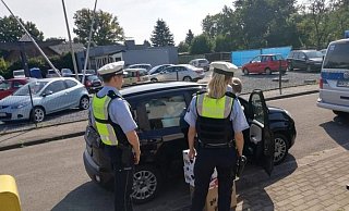 Zwei Beamte vor einem vollgepackten Auto. - Polizei Zwei Beamte vor einem vollgepackten Auto. - Polizei