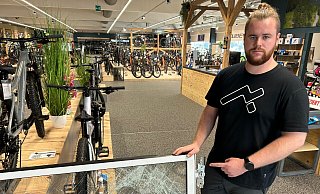 Werkstattleiter Dominik Riegel (24) zeigt die zersplitterte Eingangstür. des Cube-Fahrradladen in Gütersloh. - Christian Bröder Werkstattleiter Dominik Riegel (24) zeigt die zersplitterte Eingangstür. des Cube-Fahrradladen in Gütersloh. - Christian Bröder