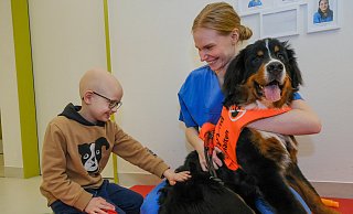 Physiotherapeutin Michalina Chlanda-Stieben mit Berner Sennenhund Mochi und Patient Filip (7) in der neuen Kinderklinik in Bethel. - Andreas Zobe Physiotherapeutin Michalina Chlanda-Stieben mit Berner Sennenhund Mochi und Patient Filip (7) in der neuen Kinderklinik in Bethel. - Andreas Zobe
