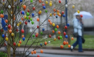 Bunte Ostereier bewegen sich an einem Baum im stürmischen Wind. - picture alliance / dpa Bunte Ostereier bewegen sich an einem Baum im stürmischen Wind. - picture alliance / dpa