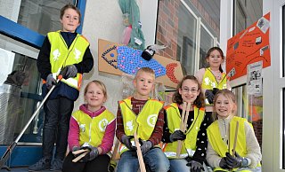 Die OGS-Kinder Bo, Lena, Mika, Guilia, Celina und Julia (v. l.) haben schon einmal ihre Warnwesten übergezogen. Mit Zangen werden sie beim Müllsammeln helfen. Im Hintergrund ist ein von den Schülern gestalteten Fisch aus Flaschendeckeln und anderem Abfall zu sehen. - Karin Prignitz Die OGS-Kinder Bo, Lena, Mika, Guilia, Celina und Julia (v. l.) haben schon einmal ihre Warnwesten übergezogen. Mit Zangen werden sie beim Müllsammeln helfen. Im Hintergrund ist ein von den Schülern gestalteten Fisch aus Flaschendeckeln und anderem Abfall zu sehen. - Karin Prignitz
