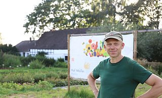 Henning Möller steht vor dem großen Schild, was den Autofahrern signalisieren soll, wo der Hof ist. Direkt daneben ist der Parkplatz. - Lena Kley Henning Möller steht vor dem großen Schild, was den Autofahrern signalisieren soll, wo der Hof ist. Direkt daneben ist der Parkplatz. - Lena Kley