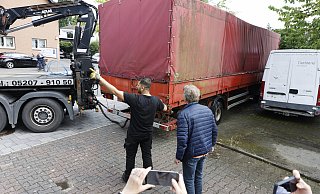 Auch der große rote Iveco-Laster mit Aufleger wird abtransportiert. Auf der Ladefläche unter der Plane stehen ein Mercedes und ein Citroën - auch sie wurden mitgenommen. - Privat Auch der große rote Iveco-Laster mit Aufleger wird abtransportiert. Auf der Ladefläche unter der Plane stehen ein Mercedes und ein Citroën - auch sie wurden mitgenommen. - Privat