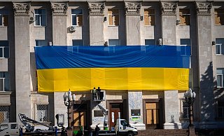Die Fassade eines Verwaltungsgebäudes in der ukrainischen Stadt Cherson wird mit einer riesigen Nationalfahne geschmückt. - Efrem Lukatsky/AP/dpa Die Fassade eines Verwaltungsgebäudes in der ukrainischen Stadt Cherson wird mit einer riesigen Nationalfahne geschmückt. - Efrem Lukatsky/AP/dpa