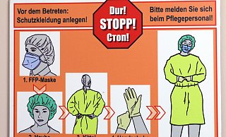 Ein Warnschild zeigt, wie Schutzkleidung angelegt wird. - Frank-Michael Kiel-Steinkamp,Frank-Michael Kiel-Steinkamp Ein Warnschild zeigt, wie Schutzkleidung angelegt wird. - Frank-Michael Kiel-Steinkamp,Frank-Michael Kiel-Steinkamp