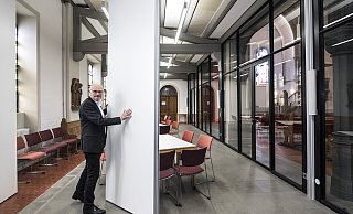 Pfarrer Christoph Steffen demonstriert, wie man mit Hilfe einer Trennwand mehrere Räume unter der Empore erhält. - © Jörg Dieckmann -www.dieckmann-fotodesign.de Pfarrer Christoph Steffen demonstriert, wie man mit Hilfe einer Trennwand mehrere Räume unter der Empore erhält. - © Jörg Dieckmann -www.dieckmann-fotodesign.de