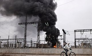Nach einem russischen Angriff fährt ein Mann mit seinem Rad an einem brennenden Elektrizitätswerk in Charkiw vorbei. - Yevhen Titov/AP/dpa Nach einem russischen Angriff fährt ein Mann mit seinem Rad an einem brennenden Elektrizitätswerk in Charkiw vorbei. - Yevhen Titov/AP/dpa