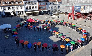 Die mehr als 150 Streikenden bilden bei der Kundgebung auf dem Paderborner Marktplatz ein buntes Peace-Zeichen, um gegen den Krieg in der Ukraine zu protestieren. - Birger Berbüsse Die mehr als 150 Streikenden bilden bei der Kundgebung auf dem Paderborner Marktplatz ein buntes Peace-Zeichen, um gegen den Krieg in der Ukraine zu protestieren. - Birger Berbüsse