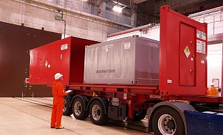 Ein sogenannter Konradcontainer mit Atommüll wird in einem roten Transportcontainer verstaut und dann per Lkw abgefahren. Die Anlieferung im geplanten Logistikzentrum Würgassen soll zum Teil über die Straße ablaufen. - BGZ Ein sogenannter Konradcontainer mit Atommüll wird in einem roten Transportcontainer verstaut und dann per Lkw abgefahren. Die Anlieferung im geplanten Logistikzentrum Würgassen soll zum Teil über die Straße ablaufen. - BGZ