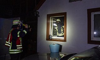 Zwei Feuerwehrmänner untersuchen das Brandhaus. - Michael Horst/Feuerwehr Porta Zwei Feuerwehrmänner untersuchen das Brandhaus. - Michael Horst/Feuerwehr Porta