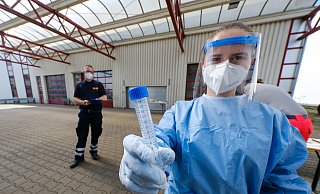 Mitarbeiter des Arbeiter-Samariter-Bunds (ASB) in Schutzkleidungen nehmen die Abstriche von rund 100 Schülern und Lehrern in der mobilen Teststation an der Feldstraße. Die Ergebnisse könnten bis zum Wochenende vorliegen. - Andreas Zobe/NW Mitarbeiter des Arbeiter-Samariter-Bunds (ASB) in Schutzkleidungen nehmen die Abstriche von rund 100 Schülern und Lehrern in der mobilen Teststation an der Feldstraße. Die Ergebnisse könnten bis zum Wochenende vorliegen. - Andreas Zobe/NW