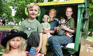 Jola spielt mit den Fundsachen der Recycling-Börse. Mama Sibylle hat derweil mit Nikki und deren Kindern Mattis und Klein-Tilda im Müllcontainer-"Strandkorb" Platz genommen. Die Kopfhörer schützen die kleinen Ohren vor zu lauter Musik. - Barbara Franke Jola spielt mit den Fundsachen der Recycling-Börse. Mama Sibylle hat derweil mit Nikki und deren Kindern Mattis und Klein-Tilda im Müllcontainer-"Strandkorb" Platz genommen. Die Kopfhörer schützen die kleinen Ohren vor zu lauter Musik. - Barbara Franke