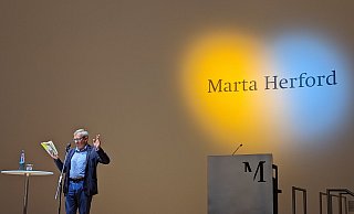 Ein Herz leuchtet in den Farben der Ukraine während Wladimir Kaminer im Marta liest. - Susanne Barth Ein Herz leuchtet in den Farben der Ukraine während Wladimir Kaminer im Marta liest. - Susanne Barth