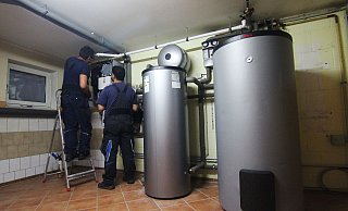 Zwei Handwerker stellen eine Wärmepumpe im Keller einer Doppelhaushälfte ein. - Doreen Garud/dpa Zwei Handwerker stellen eine Wärmepumpe im Keller einer Doppelhaushälfte ein. - Doreen Garud/dpa