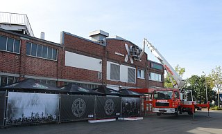Ein Kran nimmt am Donnerstagvormittag das riesige rote X von der Fassade ab. An die Stelle soll für die Eröffnung erstmal nur ein Banner kommen. - Claus Frickemeier Ein Kran nimmt am Donnerstagvormittag das riesige rote X von der Fassade ab. An die Stelle soll für die Eröffnung erstmal nur ein Banner kommen. - Claus Frickemeier