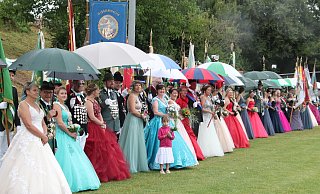 Defilee unter Schirmen: Die zahlreichen Königspaare nehmen – gut beschirmt – auf dem Sportplatz Aufstellung zur großen Parade. - Burkhard Battran Defilee unter Schirmen: Die zahlreichen Königspaare nehmen – gut beschirmt – auf dem Sportplatz Aufstellung zur großen Parade. - Burkhard Battran