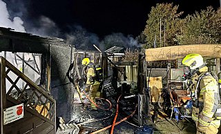 Feuerwehrleute durchsuchen die Trümmer der festen Veranda neben dem verbrannten Mobilheim, die aus Holzbauteilen bestand. - Ralph Meyer Feuerwehrleute durchsuchen die Trümmer der festen Veranda neben dem verbrannten Mobilheim, die aus Holzbauteilen bestand. - Ralph Meyer