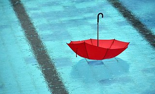 Ein Symbol für den verregneten Sommer in OWLs Freibädern: Ein roter Regenschirm treibt in einem leeren Schwimmbecken. - Ralf Hirschberger/dpa-Zentralbil Ein Symbol für den verregneten Sommer in OWLs Freibädern: Ein roter Regenschirm treibt in einem leeren Schwimmbecken. - Ralf Hirschberger/dpa-Zentralbil
