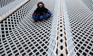 Ein Junge rutscht auf einem Schlauchring eine Rodelbahn hinab. - Themenbild: picture alliance/dpa/Alexander Demianchuk Ein Junge rutscht auf einem Schlauchring eine Rodelbahn hinab. - Themenbild: picture alliance/dpa/Alexander Demianchuk