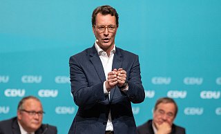 Hendrik Wüst, designierter neuer Landesvorsitzender der CDU Nordrhein-Westfalen, spricht zu den Delegierten. Hinten sitzen Generalsekretär Josef Hovenjürgen (l) und Ministerpräsident Armin Laschet. - picture alliance/dpa Hendrik Wüst, designierter neuer Landesvorsitzender der CDU Nordrhein-Westfalen, spricht zu den Delegierten. Hinten sitzen Generalsekretär Josef Hovenjürgen (l) und Ministerpräsident Armin Laschet. - picture alliance/dpa