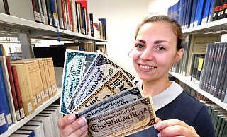 Tut nur so, als sei sie schwerreich: Güterslohs Stadtarchivarin Julia Kuklik. Sie hält ein Bündel Geldscheine, mit dem sie einst kaum einen ordentlichen Einkauf hätte tätigen können. - Andreas Frücht Tut nur so, als sei sie schwerreich: Güterslohs Stadtarchivarin Julia Kuklik. Sie hält ein Bündel Geldscheine, mit dem sie einst kaum einen ordentlichen Einkauf hätte tätigen können. - Andreas Frücht