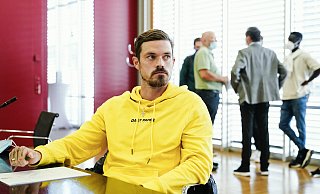 Saarbrückens Spieler Dennis Erdmann sitzt im Verhandlungssaal. Rechts im Hintergrund sind unter anderem Spieler und Funktionäre des 1. FC Magdeburg zu sehen. - picture alliance/dpa Saarbrückens Spieler Dennis Erdmann sitzt im Verhandlungssaal. Rechts im Hintergrund sind unter anderem Spieler und Funktionäre des 1. FC Magdeburg zu sehen. - picture alliance/dpa