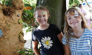 Die Freundinnen Elina (links) und Lina gestalten beim Waldfest im Dobergmuseum am Stand von Primelgrün e. V. mit Ton eine Skulptur an einem der Bäume im Garten des Bünder Museums. - GERALD DUNKEL Die Freundinnen Elina (links) und Lina gestalten beim Waldfest im Dobergmuseum am Stand von Primelgrün e. V. mit Ton eine Skulptur an einem der Bäume im Garten des Bünder Museums. - GERALD DUNKEL