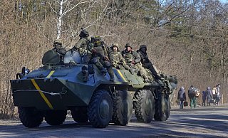 Ukrainische Soldaten auf einem gepanzerten Mannschaftswagen fahren an Menschen vorbei, die ihre Habseligkeiten auf der Flucht vor dem Konflikt tragen, in der Region Wyschgorod in der Nähe von Kiew. - dpa Ukrainische Soldaten auf einem gepanzerten Mannschaftswagen fahren an Menschen vorbei, die ihre Habseligkeiten auf der Flucht vor dem Konflikt tragen, in der Region Wyschgorod in der Nähe von Kiew. - dpa