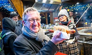 Oliver Münchow genießt eine Krakauerwurst vom Stand von Christina Schneider auf dem Altstädter Kirchplatz. - Sarah Jonek Oliver Münchow genießt eine Krakauerwurst vom Stand von Christina Schneider auf dem Altstädter Kirchplatz. - Sarah Jonek