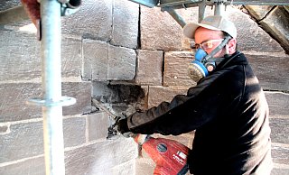 Mit einem Stemmhammer löst Steinmetz Christian Kamp das verwitterte Gestein aus der Wand. - Burkhard Battran Mit einem Stemmhammer löst Steinmetz Christian Kamp das verwitterte Gestein aus der Wand. - Burkhard Battran