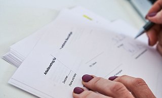 Eine Frau unterschreibt einen Arbeitsvertrag. - Annette Riedl/dpa Eine Frau unterschreibt einen Arbeitsvertrag. - Annette Riedl/dpa