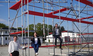 Iris Brockmeier (v. l.), Svea Ruhe und Max Weeke freuen sich auf die erste Vorstellung im Autokino Die 40 Quadratmeter große Leinwand soll an dem Stahlgerüst befestigt werden. - Klaus Karenfeld Iris Brockmeier (v. l.), Svea Ruhe und Max Weeke freuen sich auf die erste Vorstellung im Autokino Die 40 Quadratmeter große Leinwand soll an dem Stahlgerüst befestigt werden. - Klaus Karenfeld