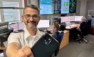 Jens Janzen leitet die Rettungsleitstelle des Kreises Paderborn. Per Smartphone können Ersthelfer nun Informationen von Unglücksorten live übermitteln. Im Hintergrund die Leitstellenmitarbeiter Michael Reitz und Christoph Hüttenschmidt (r.). - Jens Reddeker Jens Janzen leitet die Rettungsleitstelle des Kreises Paderborn. Per Smartphone können Ersthelfer nun Informationen von Unglücksorten live übermitteln. Im Hintergrund die Leitstellenmitarbeiter Michael Reitz und Christoph Hüttenschmidt (r.). - Jens Reddeker