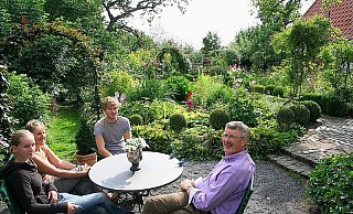 Von der Terrasse aus und der Sitzecke davor bietet sich ein herrlicher Blick ins Grüne - vorn der Bauerngarten, dem sich die Obstwiese anschließt. Der Hohlweg (l.) verbindet die Flächen. Auf dem Foto v.l. Irina Hanke mit Mutter Brigitte, Sohn Florian und Friedhelm Diebrok vom NABU. - FOTO: DIETER SCHNASE Von der Terrasse aus und der Sitzecke davor bietet sich ein herrlicher Blick ins Grüne - vorn der Bauerngarten, dem sich die Obstwiese anschließt. Der Hohlweg (l.) verbindet die Flächen. Auf dem Foto v.l. Irina Hanke mit Mutter Brigitte, Sohn Florian und Friedhelm Diebrok vom NABU. - FOTO: DIETER SCHNASE