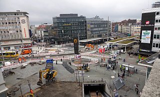 Mit Baggern wird jetzt die Hauptfläche vor der Niedernstraße aufgegraben (vorn). Rechts sind die neuen Haltestellendächer zu sehen – erstmals schon mit Grün obendrauf. Links am Pavillon gehen Passanten übers neue Pflaster. - Peter Unger Mit Baggern wird jetzt die Hauptfläche vor der Niedernstraße aufgegraben (vorn). Rechts sind die neuen Haltestellendächer zu sehen – erstmals schon mit Grün obendrauf. Links am Pavillon gehen Passanten übers neue Pflaster. - Peter Unger
