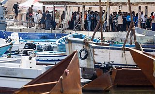 Migranten stehen an einem Hafen auf Lampedusa. - Cecilia Fabiano/LaPresse via ZUMA Press/dpa Migranten stehen an einem Hafen auf Lampedusa. - Cecilia Fabiano/LaPresse via ZUMA Press/dpa