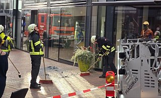 Die Einsatzkräfte der Gütersloher Berufsfeuerwehr kehren die Glassplitter der herabgestürzten Fassadenscheibe zusammen. - Kevin Hermann Die Einsatzkräfte der Gütersloher Berufsfeuerwehr kehren die Glassplitter der herabgestürzten Fassadenscheibe zusammen. - Kevin Hermann