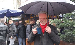 Glühwein statt Regenfrust: Gut beschirmt gönnt sich IKG-AbsolventUwe Hachmeiste am Schweinenbrunnen am Heiligabend um 12 Uhr Mittags dasbeliebte Heißgetränk. Foto: Wolfgang Döbber - Wolfgang Döbber Glühwein statt Regenfrust: Gut beschirmt gönnt sich IKG-AbsolventUwe Hachmeiste am Schweinenbrunnen am Heiligabend um 12 Uhr Mittags dasbeliebte Heißgetränk. Foto: Wolfgang Döbber - Wolfgang Döbber
