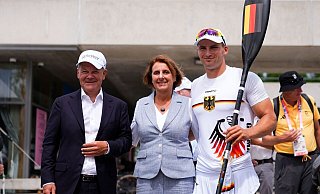 Bundeskanzler Olaf Scholz (l) und seine Frau Britta Ernst lassen sich mit Olympiasieger Tom Liebscher-Lucz fotografieren. - Lindsey Wasson/AP/dpa Bundeskanzler Olaf Scholz (l) und seine Frau Britta Ernst lassen sich mit Olympiasieger Tom Liebscher-Lucz fotografieren. - Lindsey Wasson/AP/dpa