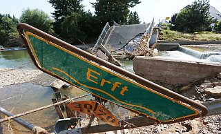 Ein Hinweisschild auf die Erft liegt in Stolzenheim vor einer zerstörte Brücke im Schutt. Der Einsatz im Rheinland und in Rheinald-Pfalz wird die künftige Ausrüstung der heimischen Wehren beeinflussen. - David Young/DPA Ein Hinweisschild auf die Erft liegt in Stolzenheim vor einer zerstörte Brücke im Schutt. Der Einsatz im Rheinland und in Rheinald-Pfalz wird die künftige Ausrüstung der heimischen Wehren beeinflussen. - David Young/DPA