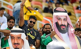 Saudische Fußballfans finden die Sport-Strategie des Königreichs um Kronprinz Mohammed bin Salman (auf dem rechten Plakat) gut. - ---/AP/dpa Saudische Fußballfans finden die Sport-Strategie des Königreichs um Kronprinz Mohammed bin Salman (auf dem rechten Plakat) gut. - ---/AP/dpa