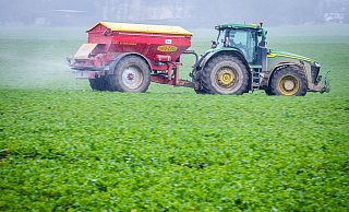 Ein Traktor fährt mit einem Streuwagen über ein Feld und bringt Dünger aus. - dpa Ein Traktor fährt mit einem Streuwagen über ein Feld und bringt Dünger aus. - dpa