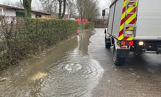 Nach dem Hochwasser sprudelt das Wasser aus der Schachtabdeckung des Kanalnetzes auf die Hainanger-Straße in Germete. - FFW Warburg Nach dem Hochwasser sprudelt das Wasser aus der Schachtabdeckung des Kanalnetzes auf die Hainanger-Straße in Germete. - FFW Warburg