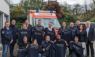 Zum Dank für ihren langjährigen ehrenamtlichen Einsatz erhielten die Rotkreuz-Sanitäter ein T-Shirt mit dem Aufdruck Retter mit Herz. - DRK Zum Dank für ihren langjährigen ehrenamtlichen Einsatz erhielten die Rotkreuz-Sanitäter ein T-Shirt mit dem Aufdruck Retter mit Herz. - DRK
