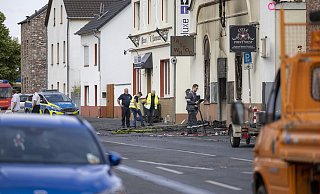 Blick durch das Absperrgitter auf das ausgebrannte Motorradgeschäft in Sankt Augustin. Nach dem Brand mit zwei toten Feuerwehrleuten laufen die Ermittlungen zur Brandursache. - picture alliance/dpa Blick durch das Absperrgitter auf das ausgebrannte Motorradgeschäft in Sankt Augustin. Nach dem Brand mit zwei toten Feuerwehrleuten laufen die Ermittlungen zur Brandursache. - picture alliance/dpa