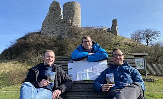 Touristiker Lucas Lambracht (v. l.), Bürgermeister Tobias Scherf und der Mobilitätsbeauftragte Jan Kolditz präsentieren am Desenberg die neue Wanderkarte. - Stadt Touristiker Lucas Lambracht (v. l.), Bürgermeister Tobias Scherf und der Mobilitätsbeauftragte Jan Kolditz präsentieren am Desenberg die neue Wanderkarte. - Stadt